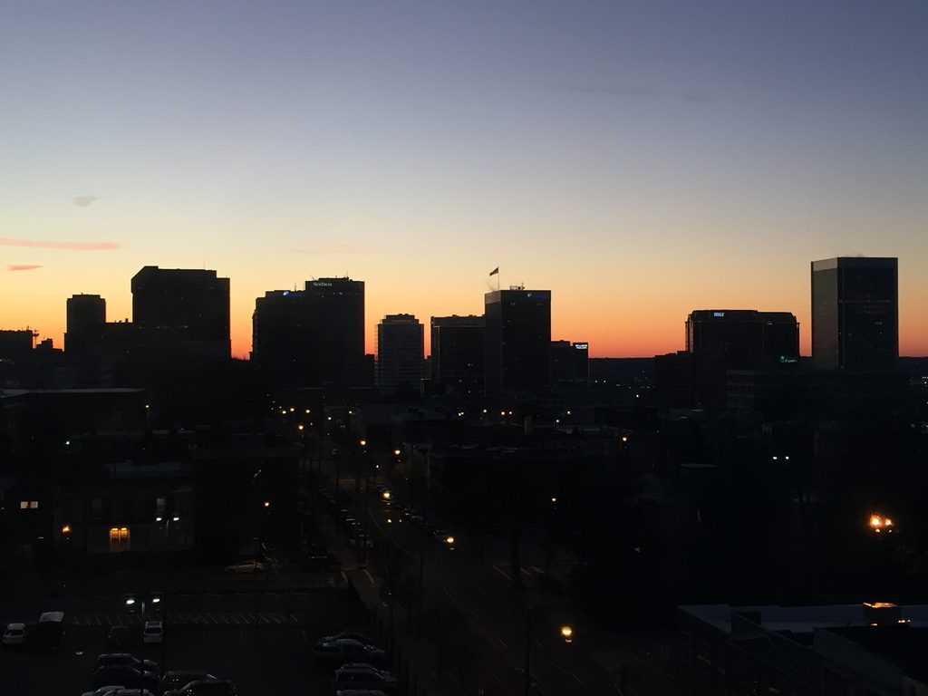 Downtown Richmond skyline silhouetted against a warm sunset sky